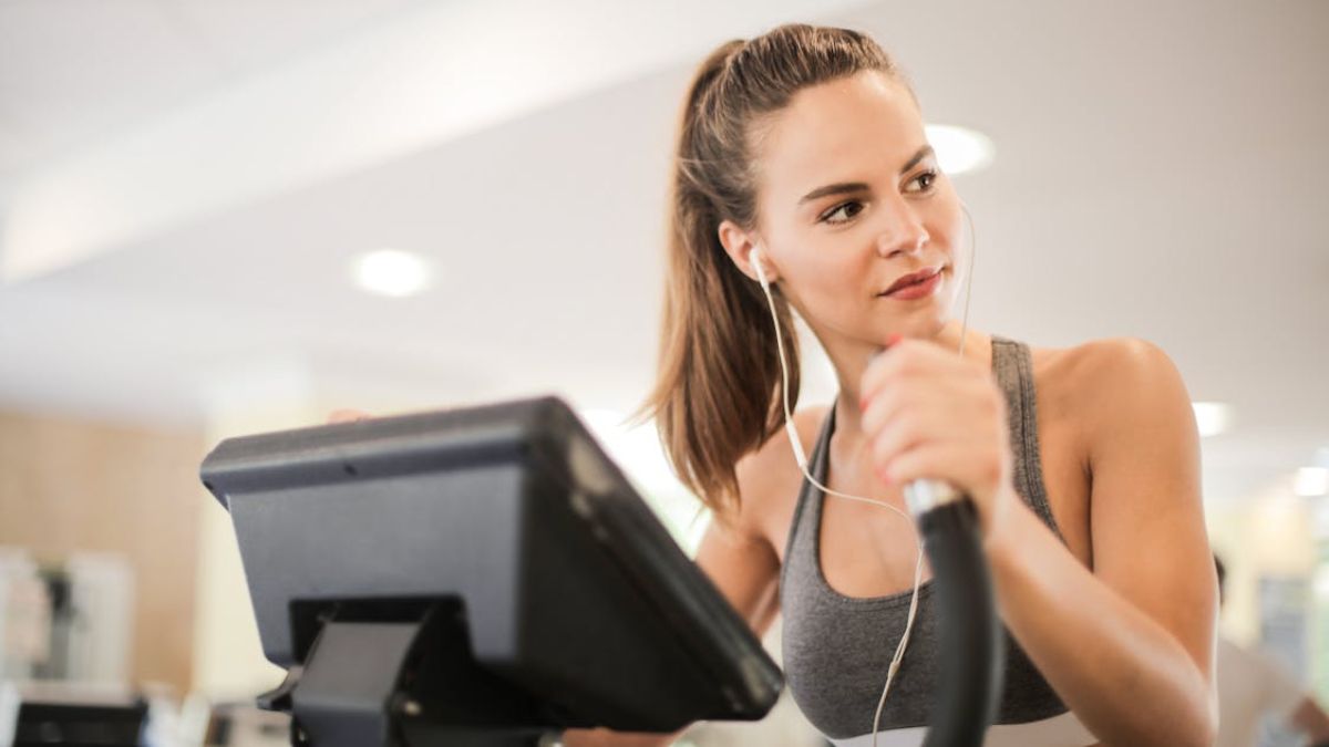 mulher fazendo cardio de fone de ouvido